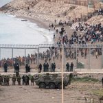18.05.2021, Spanien, Ceuta: Die spanische Armee steht an der Grenze zwischen Marokko und Spanien, in Ceuta. In der spanischen Nordafrika-Exklave Ceuta sind bis Dienstagmorgen etwa 6000 Migranten aus Marokko angekommen. Foto: Javier Fergo/AP/dpa +++ dpa-Bildfunk +++